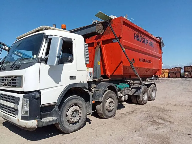 A red and white skip lorry
